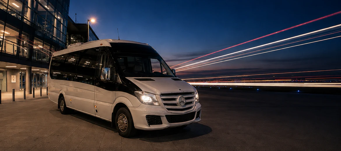 16-seater Mercedes minibus outside an airport terminal at dusk